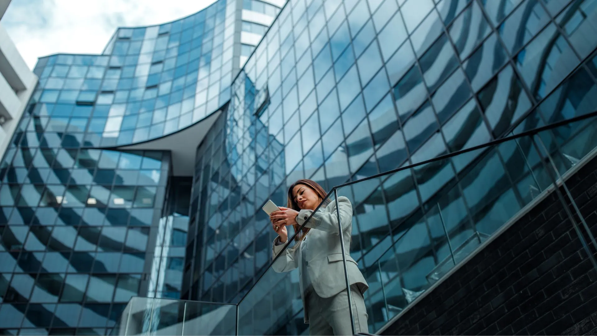 Middle-aged woman using her phone in office neighbourhood environment.